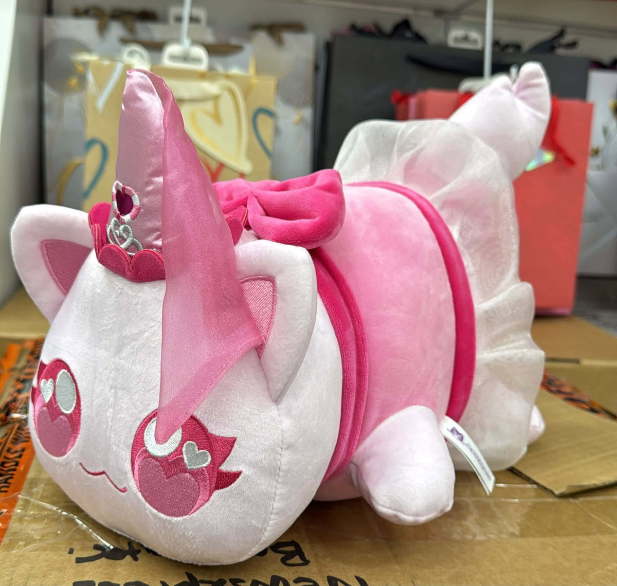 Side view of Aphmau Princess Cat plush showing pink outfit, bow, flowing veil and white ruffled details