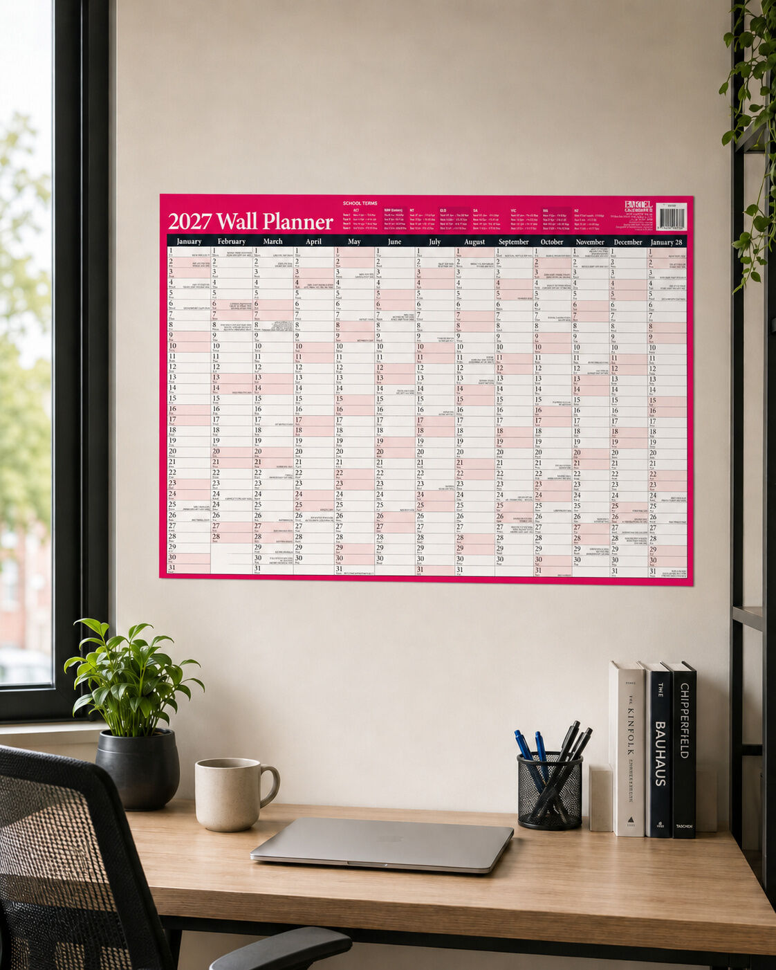 2027 Bartel Map of Australia Year Planner Red displayed on office wall above desk with laptop and stationery