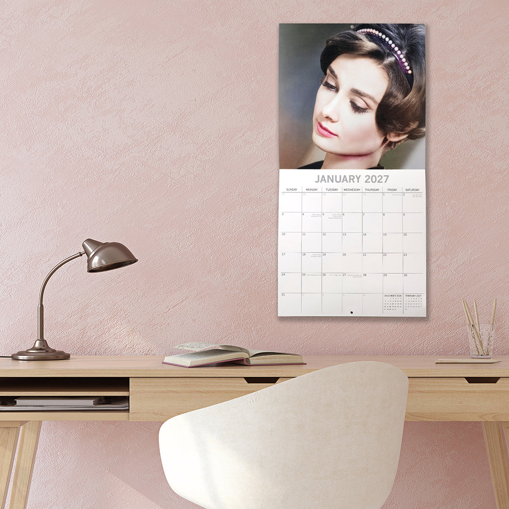 Audrey Hepburn 2027 Square Wall Calendar - January 2027 lifestyle shot hung on wall above a styled home office desk