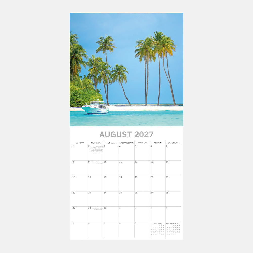 Tropical Escapes 2027 Calendar – August 2027 page featuring white yacht moored off deserted palm-fringed tropical island with turquoise water