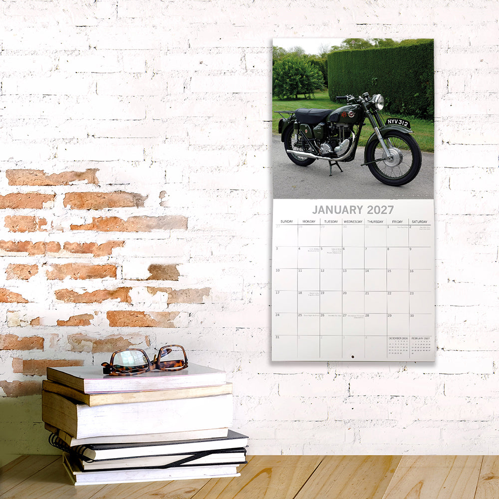 Classic Bikes 2027 Square Wall Calendar – January 2027 lifestyle shot featuring a classic AJS motorcycle on a country driveway displayed on a white brick wall