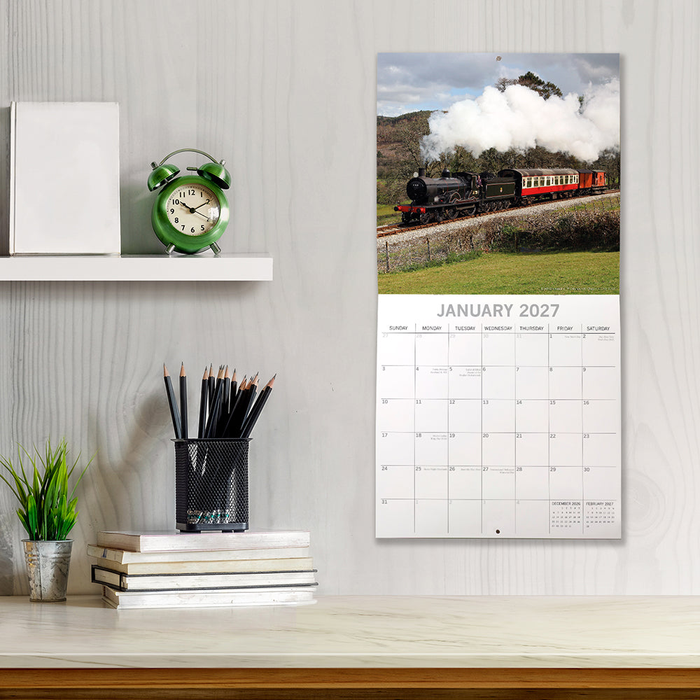 Steam Trains 2027 Square Wall Calendar – January 2027 lifestyle shot featuring a steam train with red carriages displayed on a study wall