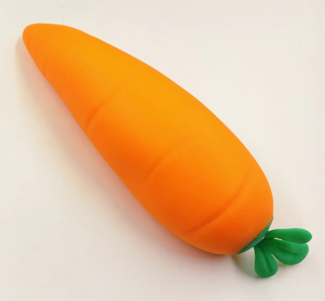 Textured orange carrot squishy with green top on a light background
