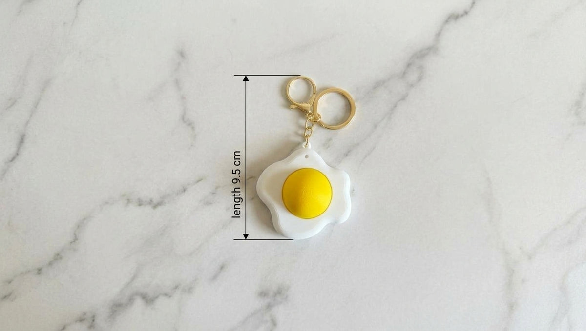 Six colourful food-themed keychains with gold-coloured keyrings on a light background
