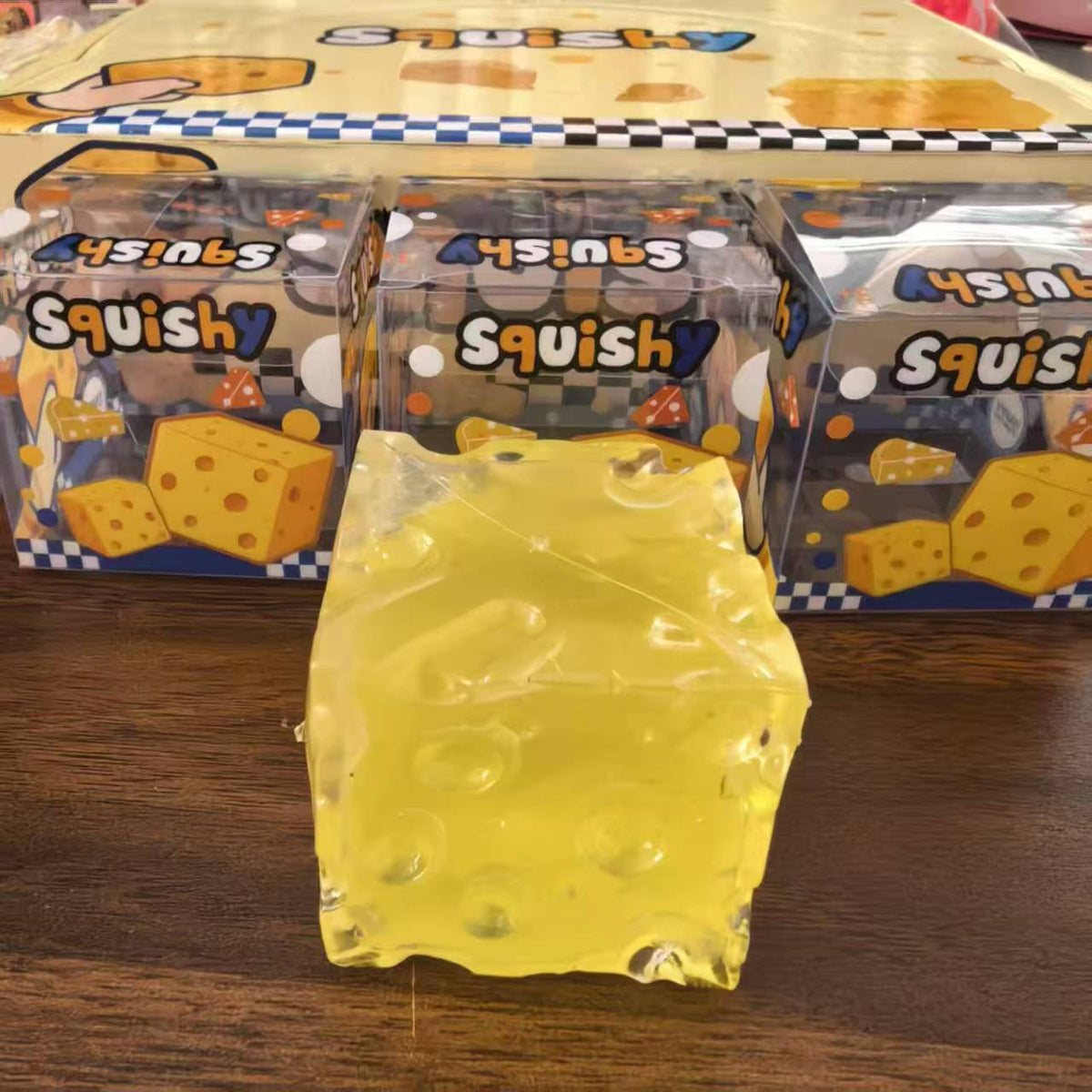 Assorted coloured cheese cube squishies beside a retail display