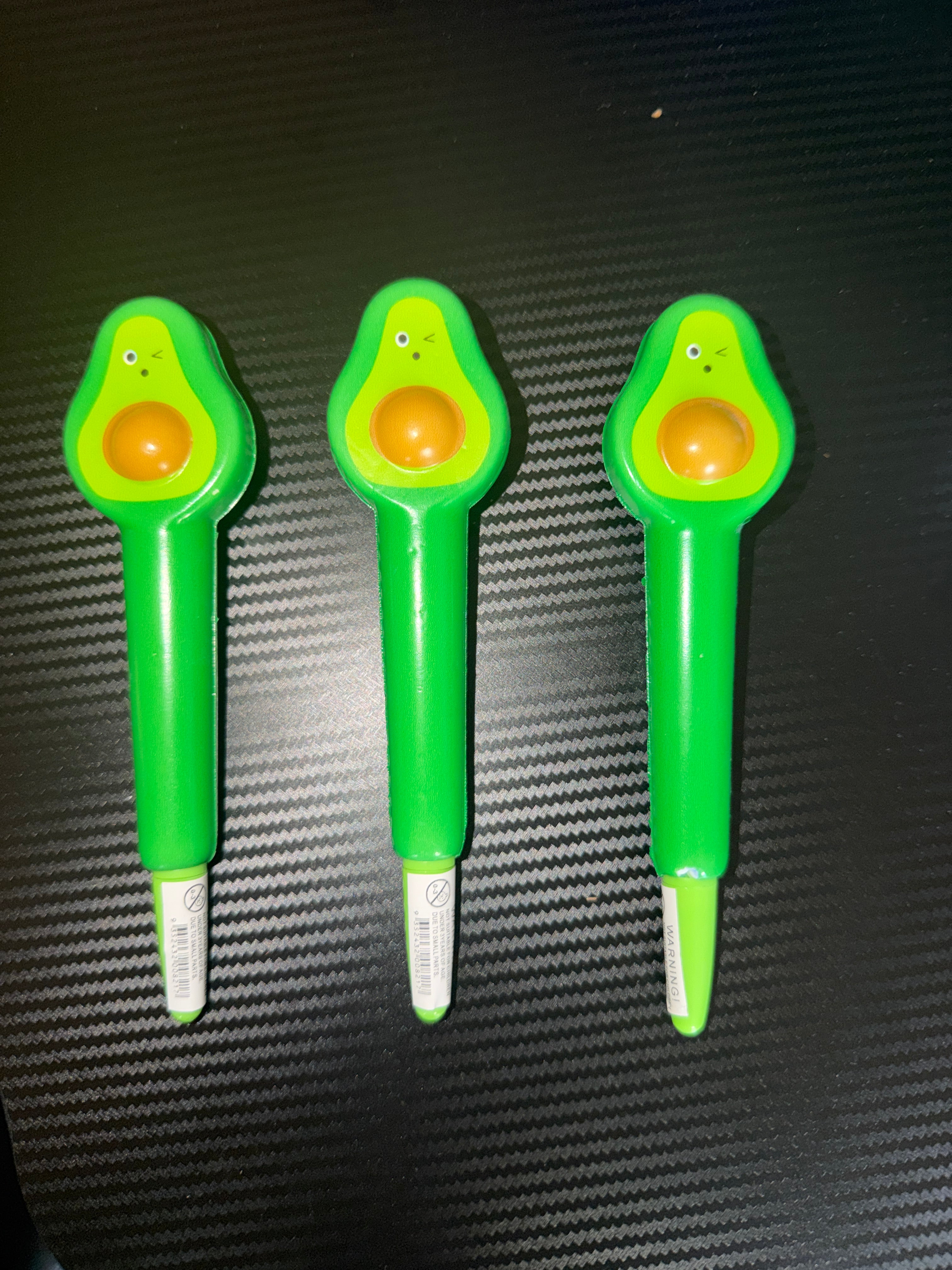 3 Squishy Avocado Pens on black background - side angle view