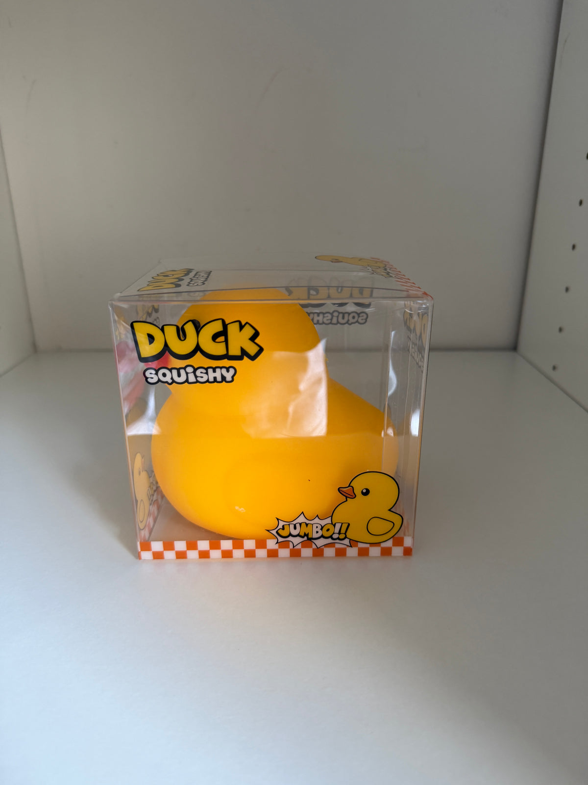 Side view of jumbo duck squishy in clear display packaging