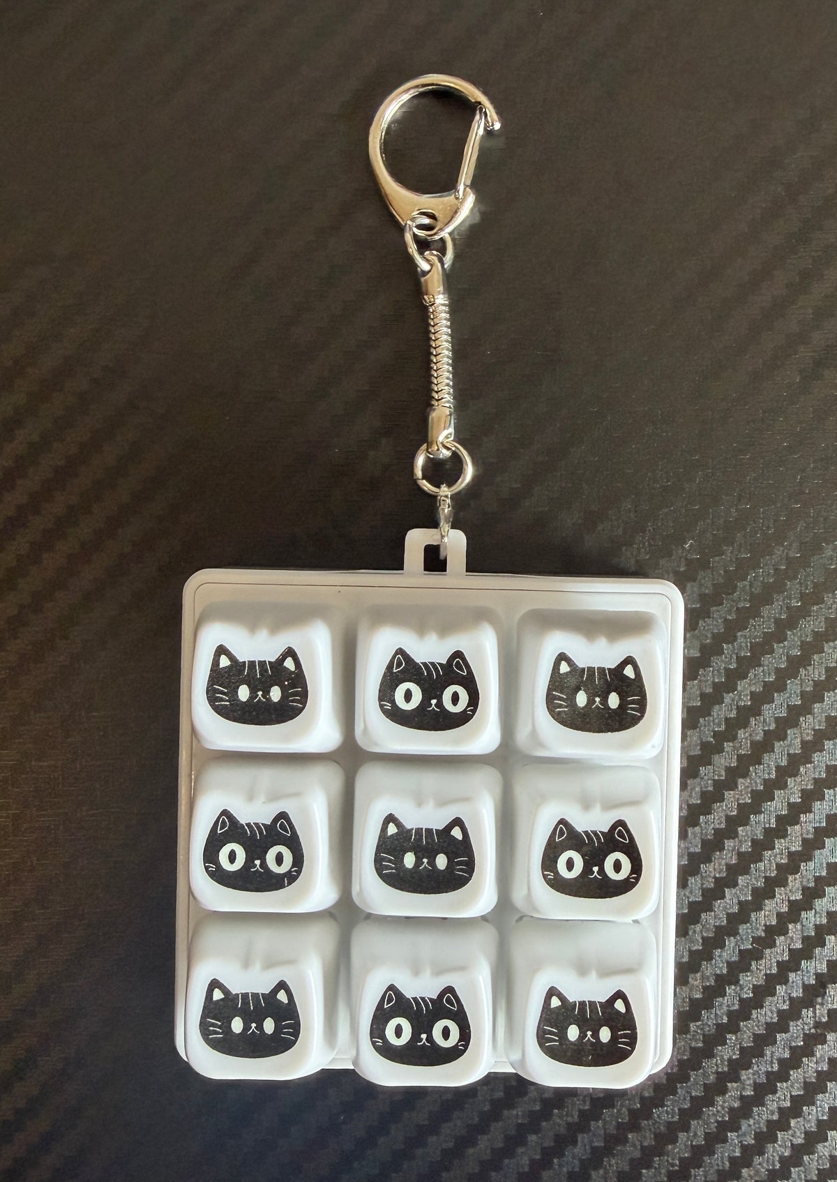 Two cat keyboard clickers shown in clear storage cases
