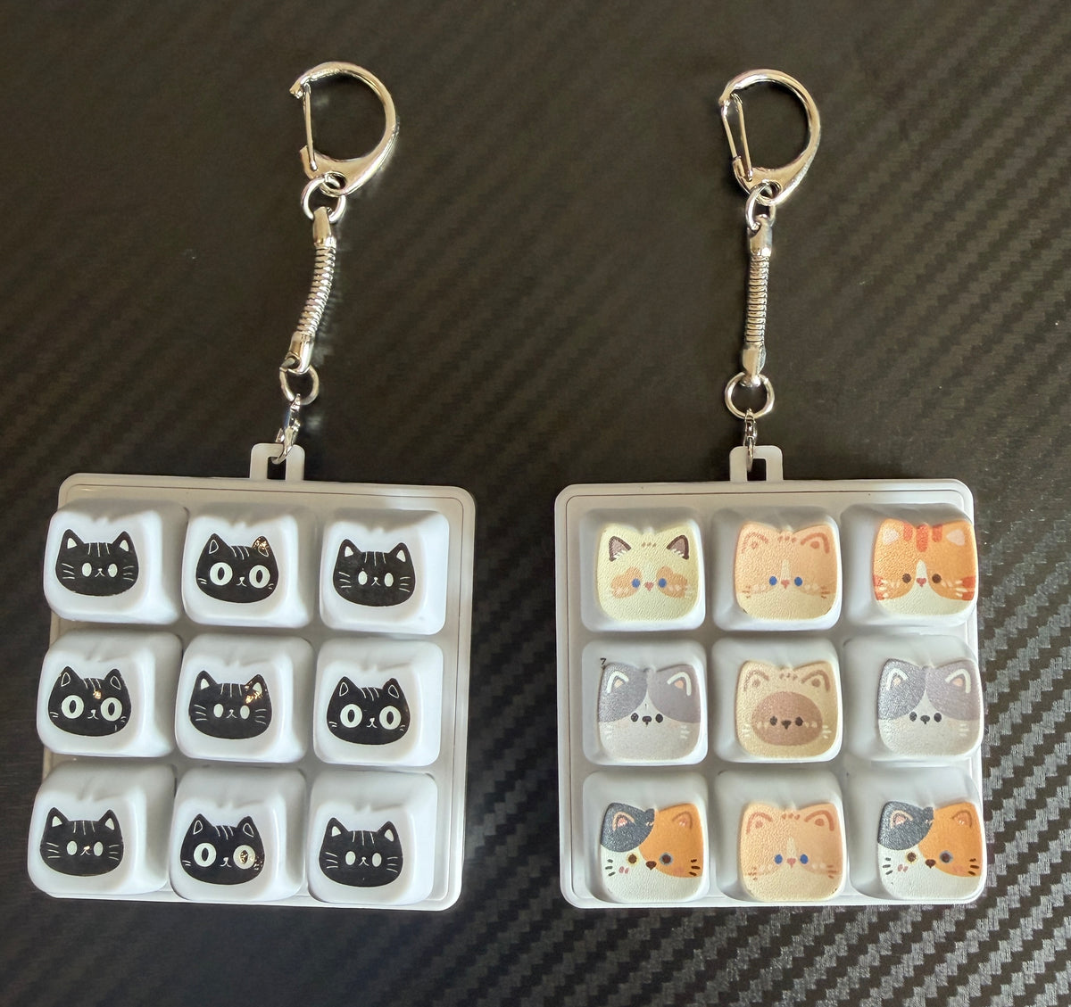 Two nine-key cat keyboard clicker keychains with black and colourful cat faces