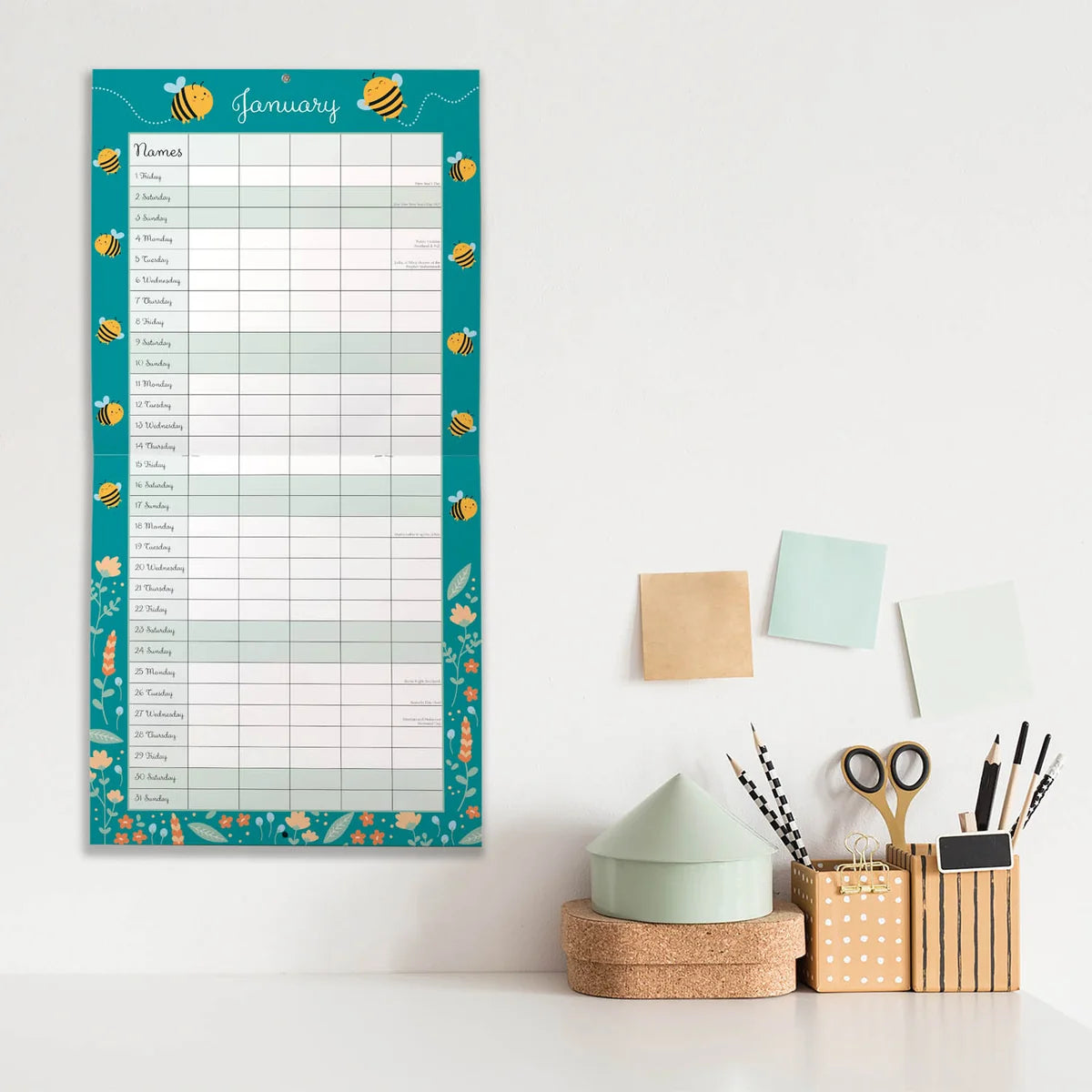 Busy Bee Family Organiser 2027 Square Wall Calendar – January 2027 lifestyle shot on teal background displayed on a desk wall