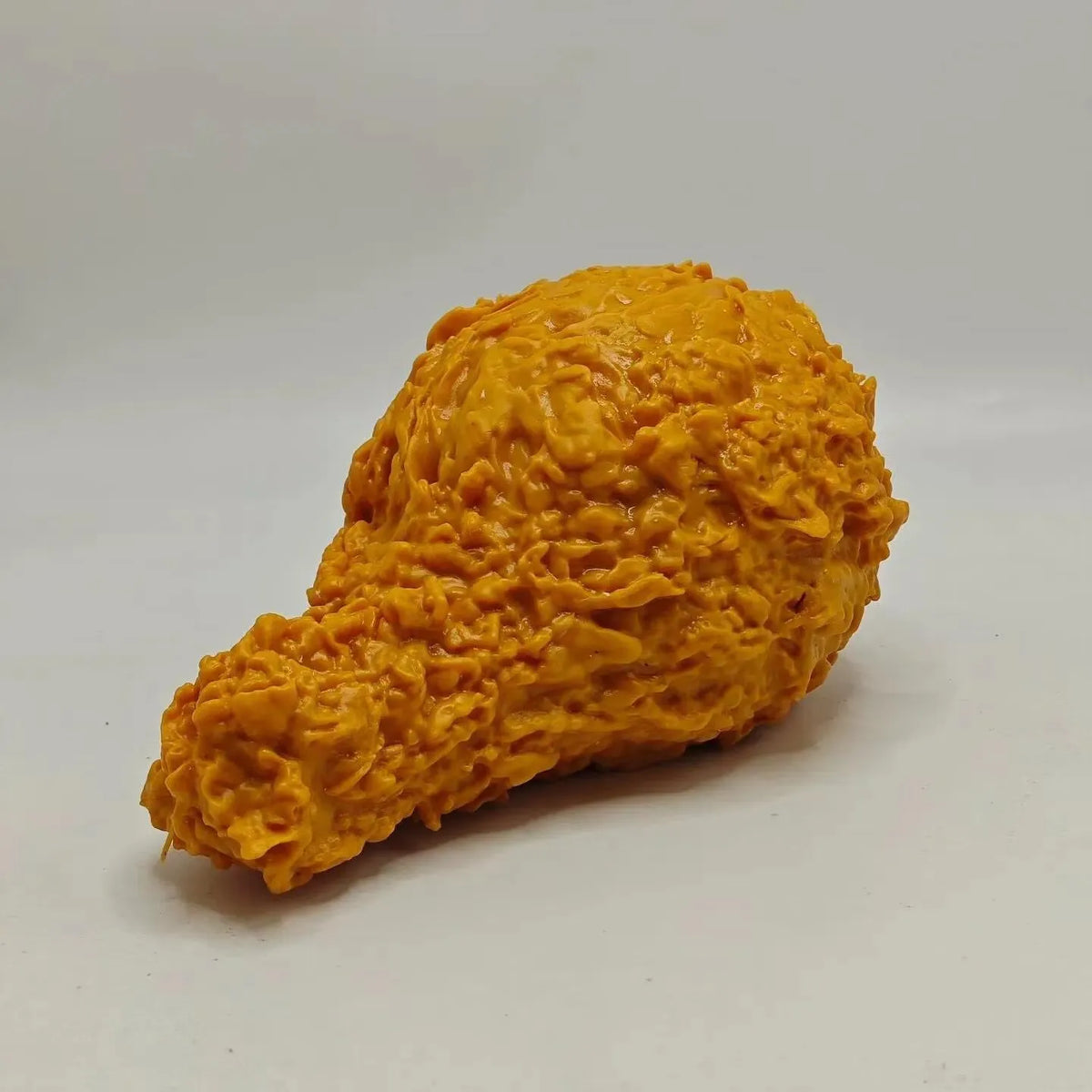 Jumbo fried chicken squishy held by its drumstick end